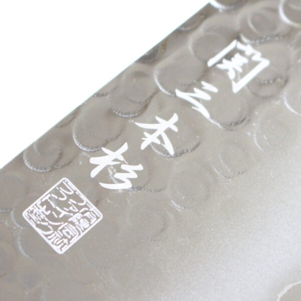 A kitchen knife focusing on its logo on the hammered blade