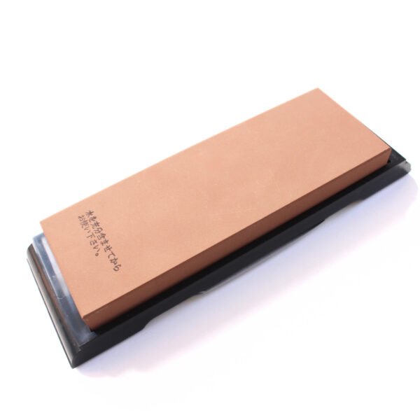 A medium grit whetstone without a case, displayed at an angle