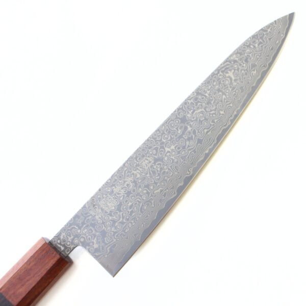 A Damascus chef knife focusing on its blade, shown diagonally