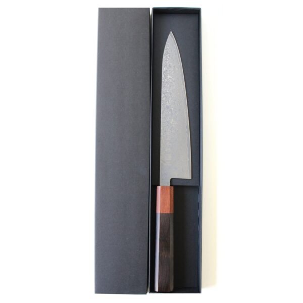 A Damascus chef knife displayed in a black box