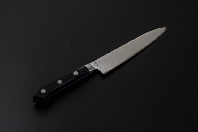 An image of a petty knife placed diagonally against a black background.