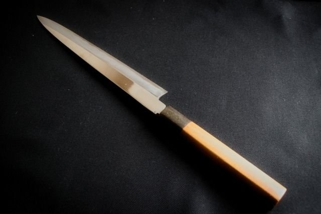 An image of a Sashimi knife displayed diagonally against a black background.