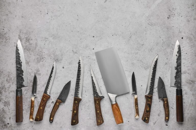 Image of various types of kitchen knives arranged horizontally on a silver background.