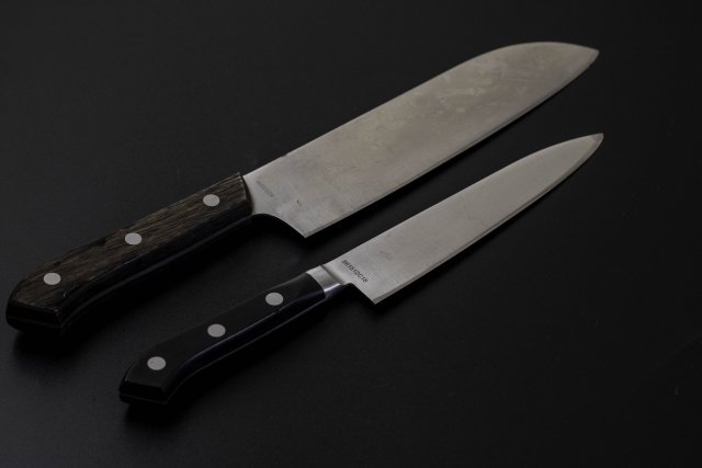All purpose and petty knives against black background