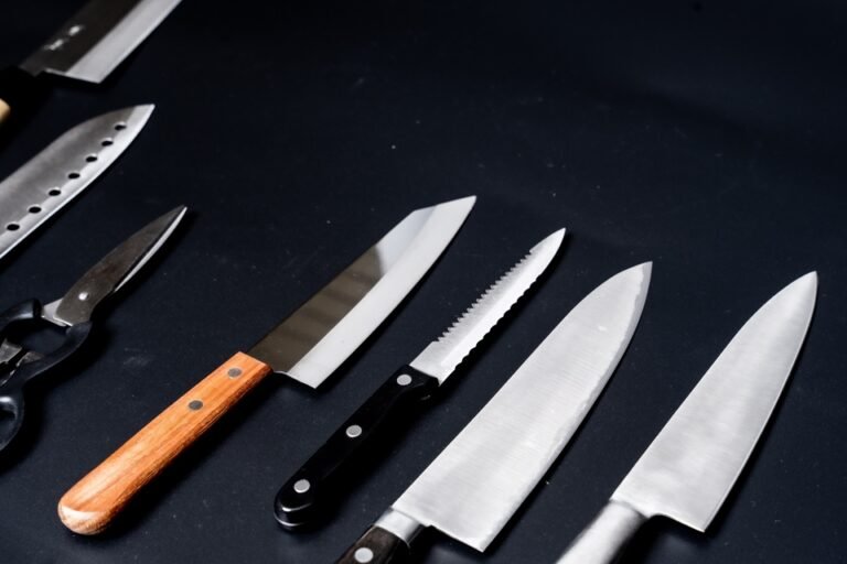 several kitchen knives displayed against a black background