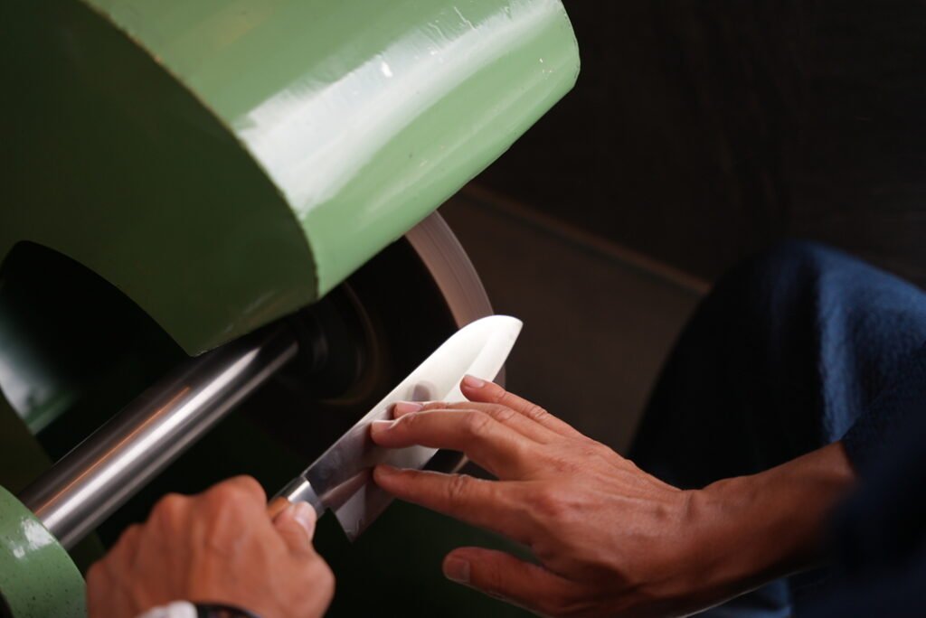 A man is sharpening a knife with a machine
