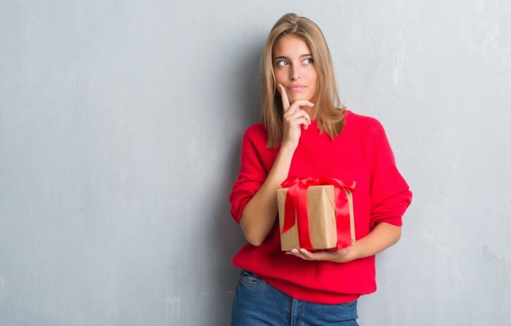 a woman holding a gift posing thoughtfully