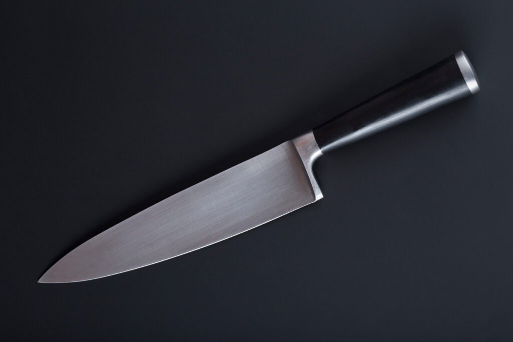 Chef's knife displayed diagonally against a black background
