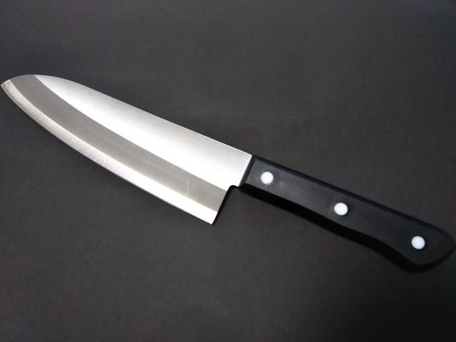 Santoku knife displayed diagonally against a black background.
