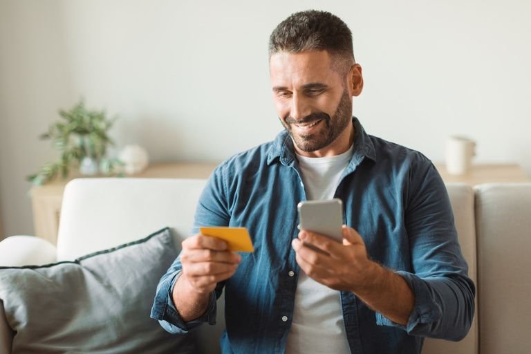 Man shopping online using a smartphone and a credit card