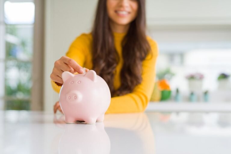 Woman putting a coin into a piggy bank